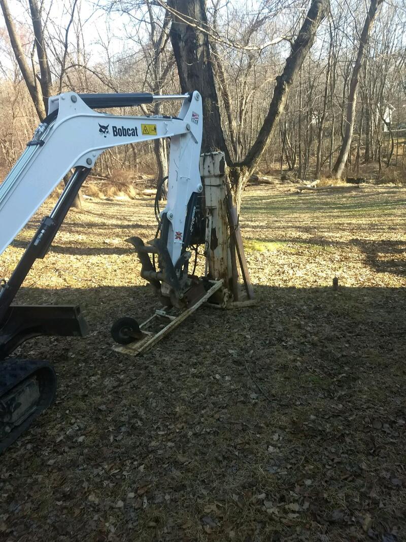 Excavator with Geoprobe machine in a wooded area