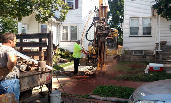 Worker operating a drilling rig for well installation